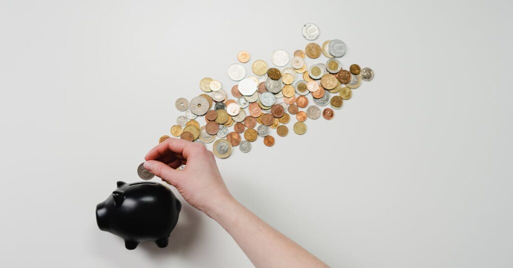 Person placing coin into a black piggy bank with scattered coins, symbolizing savings and finance.